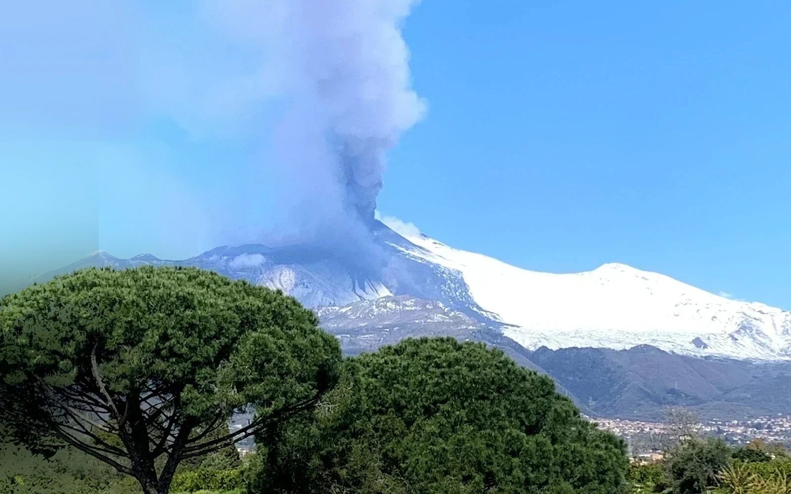 Etna in eruzione con la colonna di fumo, vista dal balcone panoramico de La Pigna delle Aci, Acireale — marzo 2021